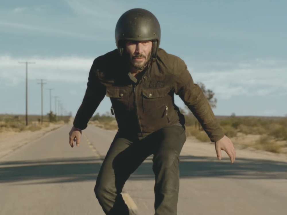 Keanu Reeves surfs a motorcycle in the Super Bowl Squarespace commercial.